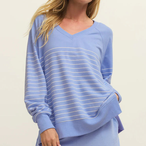 Woman wearing a light blue striped outfit on a beige background