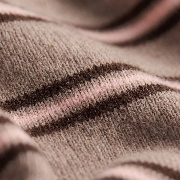 Close-up of a soft knit fabric with a striped pattern in taupe brown, dark brown, and dusty pink.
