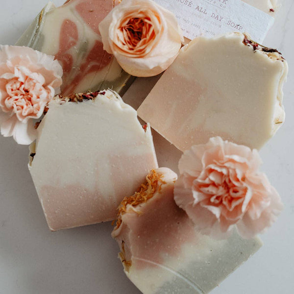 Handmade soap bars with floral decorations on a light background