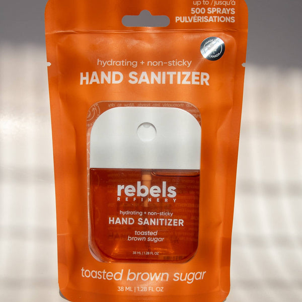 Orange package of rebels Toasted Brown Sugar hand sanitizer on a gray background
