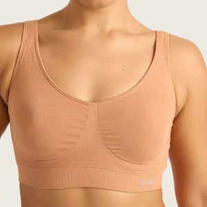 Woman wearing a beige sports bra against a plain background
