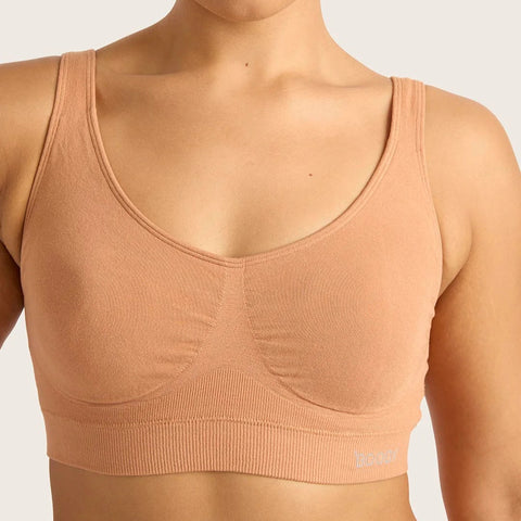 Woman wearing a beige sports bra against a plain background