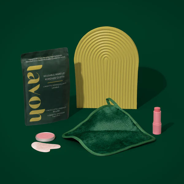 Makeup removal products including a green pad, pink bottle, and black packaging on a dark green background